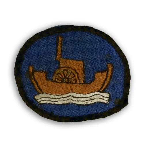 Merilottien kangasmerkki, jossa sinisellä pohjalla ruskea laiva