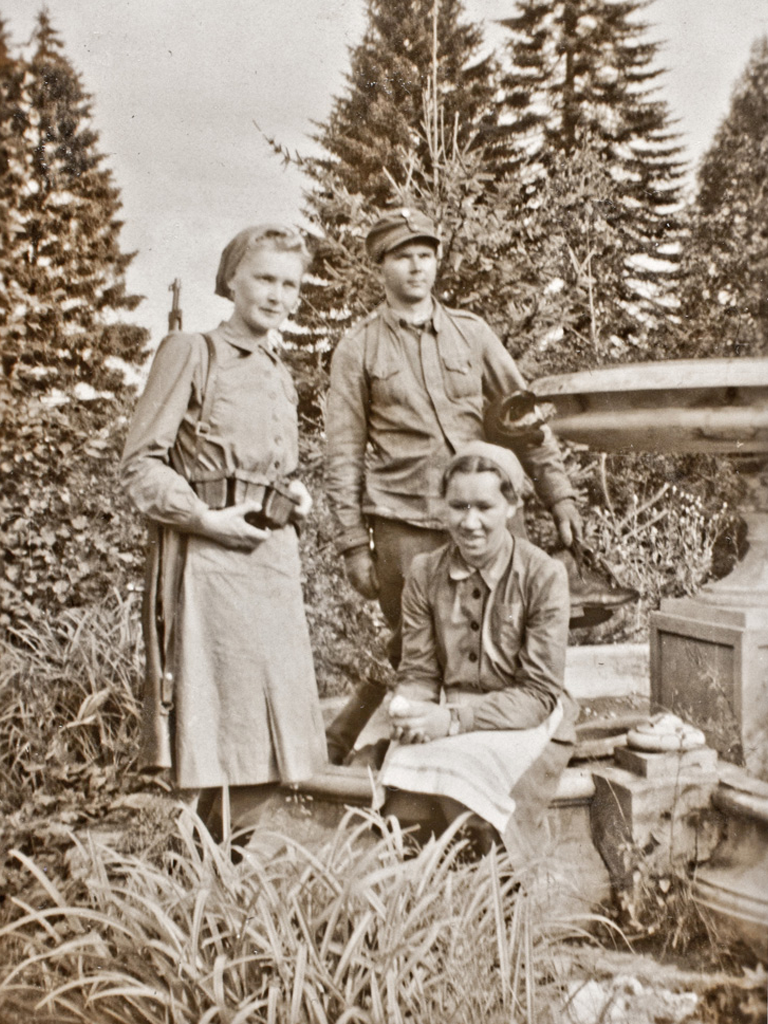 Muonituslotta Laura Juholalla on kivääri ja patruunavyö hänen retkeillessään Itä-Karjalassa yhdessä toisen lotan ja sotilaan kanssa jatkosodan aikana.