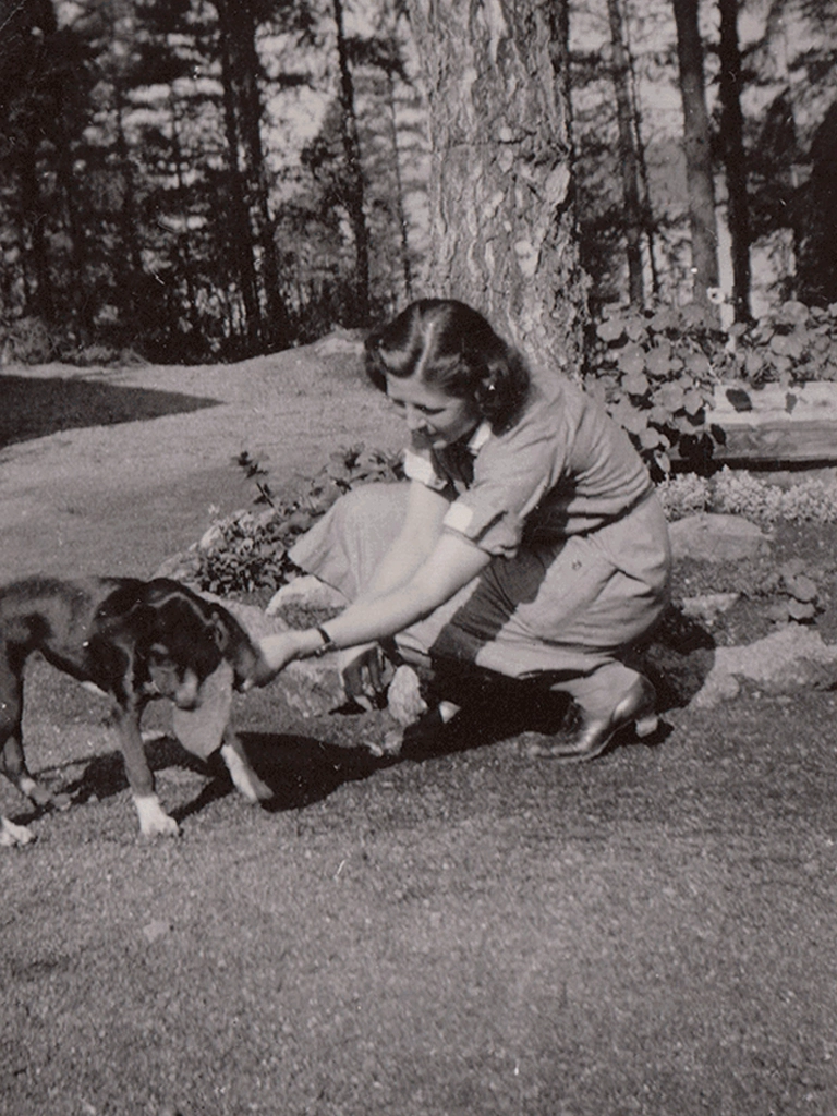Lotta leikkimässä koiran kanssa Luumäellä vuonna 1941.