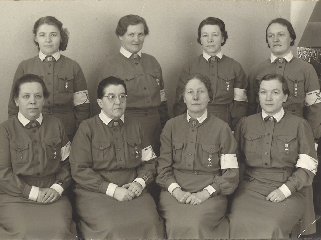 Lotta Svärd Kainuun piirijohtokunnan kaikki jäsenet ovat pukeutuneet kuvaustilanteeseen villakankaisiin edustuspukuihinsa arvo- ja koulutusmerkkeineen.