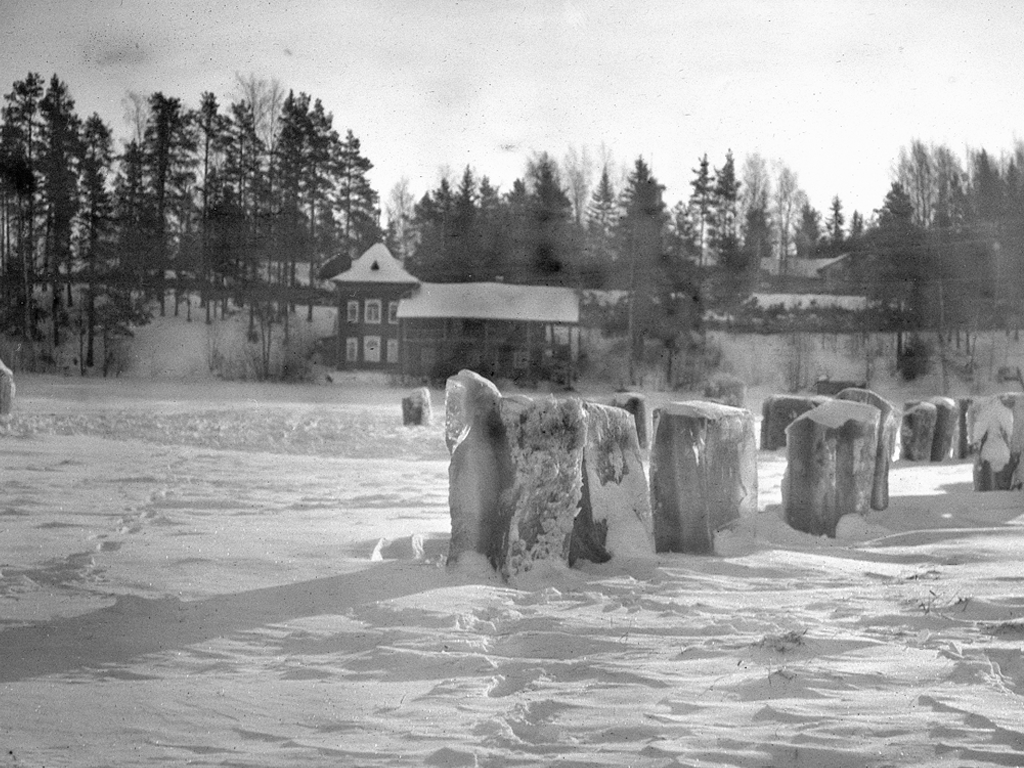 Jäälohkareita järven jäällä, taustalla rannan rakennukset. Hansen family archive.
