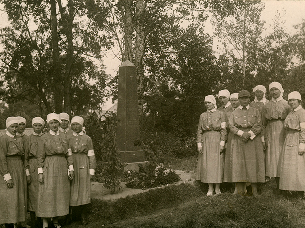 Lottia pumpulipuvuissa kunniakäynnillä muistomerkillä vuonna 1923. Valkoiset napit, huivit, sukat ja kengät poikkeavat myöhemmästä lottapukuohjeistuksesta.